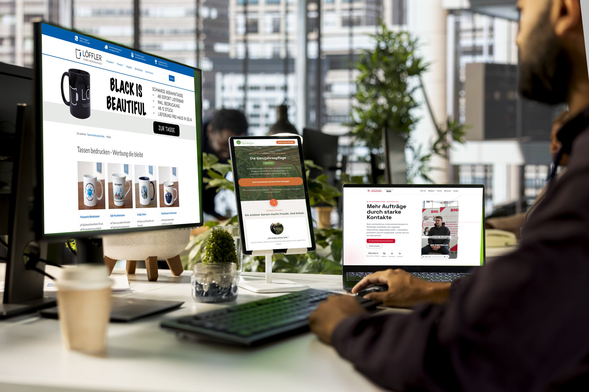 Arbeitsplatz mit Monitor, Tablet und Smartphone, auf allen Geräten dieselbe Webseite